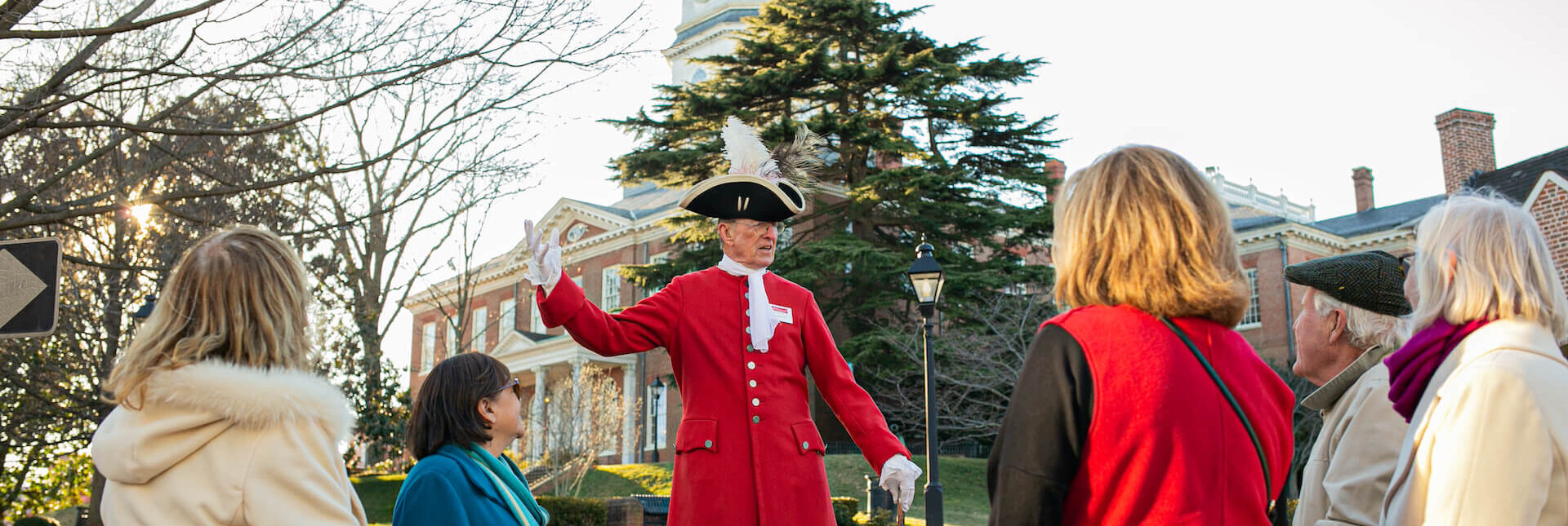 Period-attired guide with group by the Maryland State House.